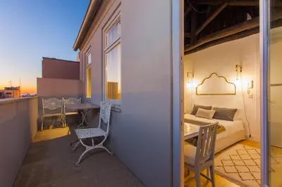 a room with a balcony with a bed and a desk at The Art Porto - Holiday Homes in Porto