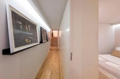 a hallway with white walls and wood floors at LovelyStay - Porto Peaceful Living W/ Backyard in Porto