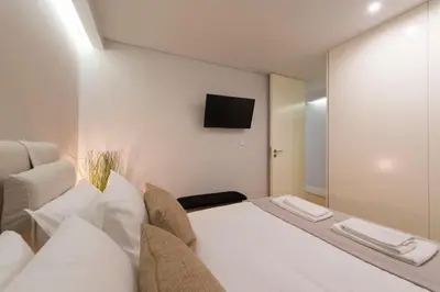 a bedroom with a bed and a tv on a wall at LovelyStay - Porto Peaceful Living W/ Backyard in Porto