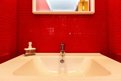 a white sink in a red bathroom with a red wall at Eiffel Porto in Porto