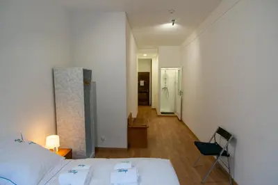 a bedroom with a bed and a chair and a hallway at Change The World Hostels - Porto - Santa Catarina in Porto