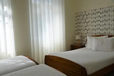 a hotel room with two beds and a window at Hotel Visconde in Porto