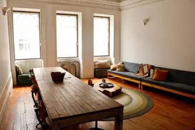 a living room with a wooden table and a couch at Alegria 1º in Porto