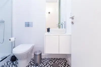 a bathroom with a white toilet and a sink at ON Apartments - Coliseu in Porto