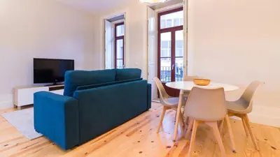 a living room with a blue couch and a table at ON Apartments - Coliseu in Porto