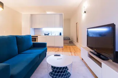 a living room with a blue couch and a tv at ON Apartments - Coliseu in Porto