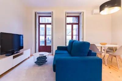 a living room with a blue couch and a tv at ON Apartments - Coliseu in Porto