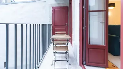 a pair of stools sitting in front of a red door at ON Apartments - Coliseu in Porto