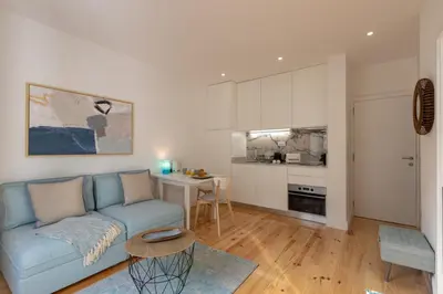 a living room with a blue couch and a kitchen at Sweet Flat 4Two in City Center, Balcony & Air Conditioning in Porto