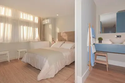 a bedroom with a bed and a bathroom with a sink at Invicta Oporto Residence in Porto