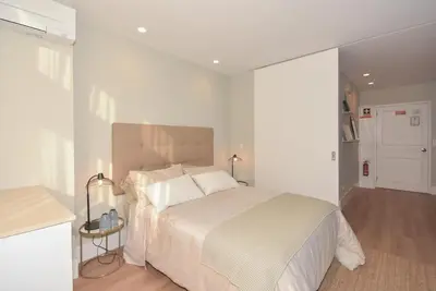 a white bedroom with a bed with white sheets and pillows at Invicta Oporto Residence in Porto