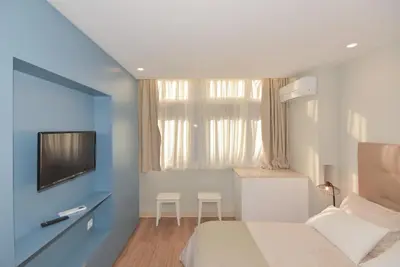 a small bedroom with a bed and a tv in it at Invicta Oporto Residence in Porto