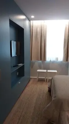 a bedroom with a bed and a tv on a wall at Invicta Oporto Residence in Porto
