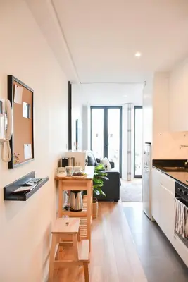 a kitchen and living room with white cabinets and a table at Comfortable&Central w/balcony-9 min walk Trindade in Porto