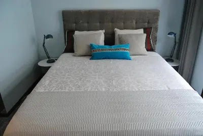 a bedroom with a large bed with blue pillows at Suite Camões in Porto