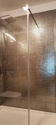 a shower with a glass door in a bathroom at Suite Camões in Porto