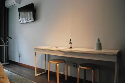a table with two stools sitting next to a wall at Suite Camões in Porto