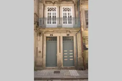 an old building with two doors and a balcony at São Miminho 3º in Porto