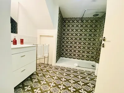 a bathroom with a shower with a tiled floor at Vitoria's Terrace Apartments in Porto