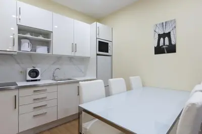 a white kitchen with white cabinets and white appliances at Yellow Tiles by PCALE in Porto