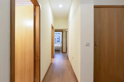 a hallway with white walls and a wooden door at Yellow Tiles by PCALE in Porto