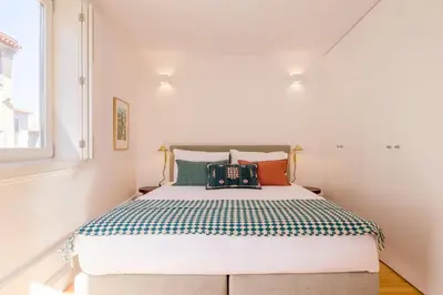 a bedroom with a large bed with colorful pillows at Clérigos 168 in Porto