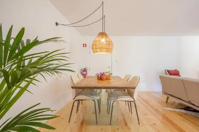 a dining room table with chairs and a potted plant at Clérigos 168 in Porto
