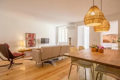 a dining room and living room with a table and chairs at Clérigos 168 in Porto