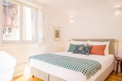 a white bedroom with a bed with pillows on it at Clérigos 168 in Porto