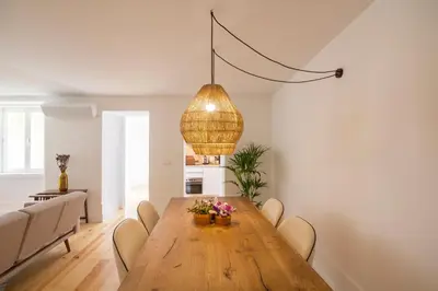 a dining room with a wooden table and chairs at Clérigos 168 in Porto