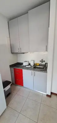 a small kitchen with white cabinets and a sink at Tower Records Apartment in Porto