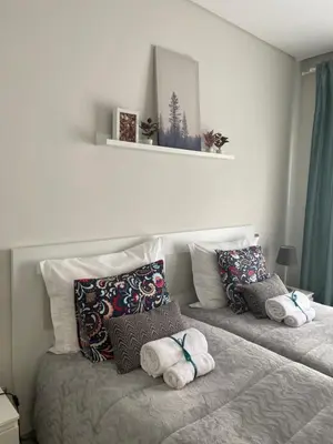 two beds with pillows on them in a bedroom at A&R Bolhão Apartment in Porto