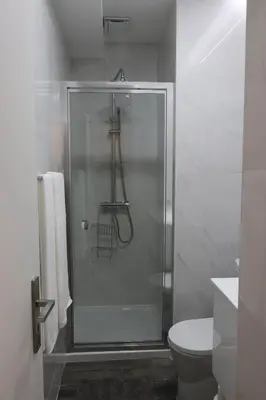 a bathroom with a glass shower with a toilet at A&R Bolhão Apartment in Porto