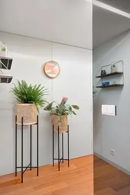 a room with two potted plants on black poles at Stylish apartment at Bolhao in Porto