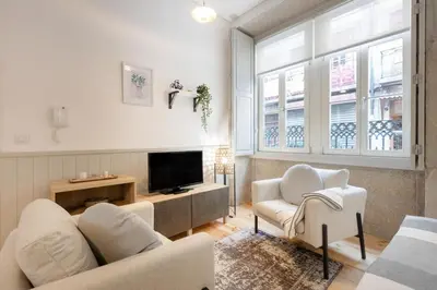 a bedroom with a large white bed and a fireplace at Sol Modern Studio @ Batalha in Porto