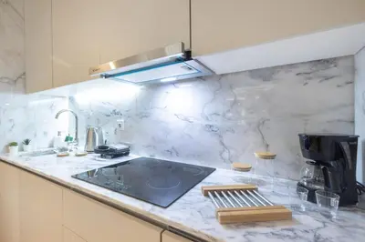 a small apartment with a bed and a table and a kitchen at Sol Modern Studio @ Batalha in Porto