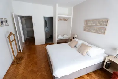 a bedroom with a white bed and a wooden floor at Alegria Cozy com Terraço - Centro do Porto in Porto