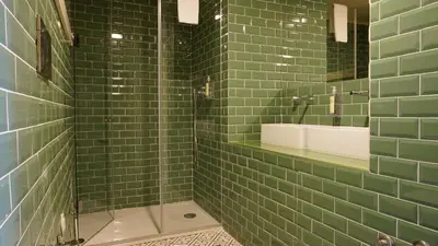 a green tiled bathroom with a shower and a sink at Oporto Maison Palace in Porto