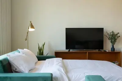 a bedroom with a bed with a television and a couch at Batalha Mezzanine Penthouse in Porto