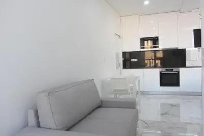 a living room with a couch and a kitchen at VB Porto City Studio, by Flat in Porto in Porto