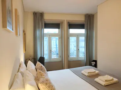 a bedroom with a bed with two towels on it at Porto Main Square Penthouse Apartment in Porto