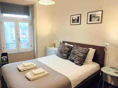 a bedroom with a bed with two towels on it at Porto Main Square Penthouse Apartment in Porto