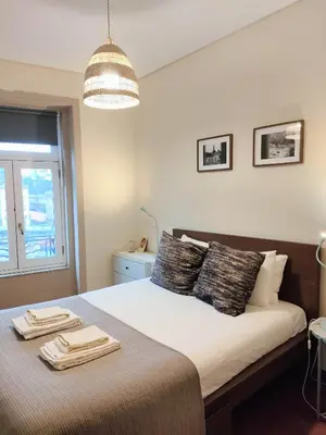 a bedroom with a bed with two towels on it at Porto Main Square Penthouse Apartment in Porto