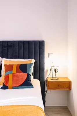 a bed with a black headboard next to a wooden table at BBA Apartments Palácio I - Douro View, Gym & Free Parking in Porto