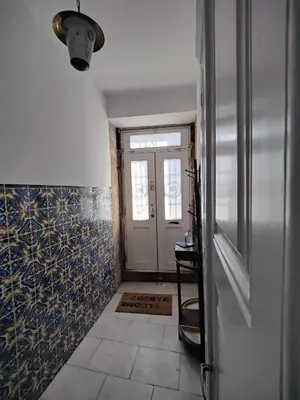 a hallway with a door and a tile floor at Casa da Rita in Porto