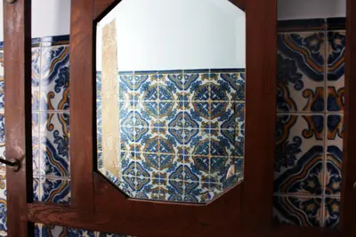 a mirror on a wooden wall with blue and white tiles at Casa da Rita in Porto