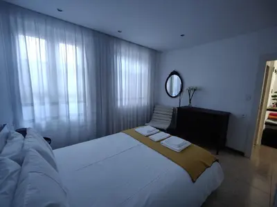 a bedroom with a large white bed and a mirror at Casa da Rita in Porto
