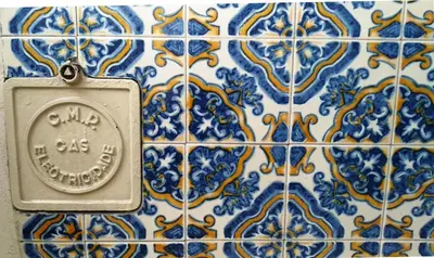 a blue and white tiled wall with a clock on it at Casa da Rita in Porto