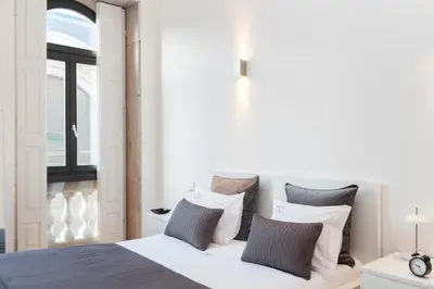 a bedroom with a bed with white sheets and pillows at BO - Bolhão Apartments in Porto