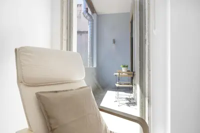 a white chair in a room with a window at BO - Bolhão Apartments in Porto
